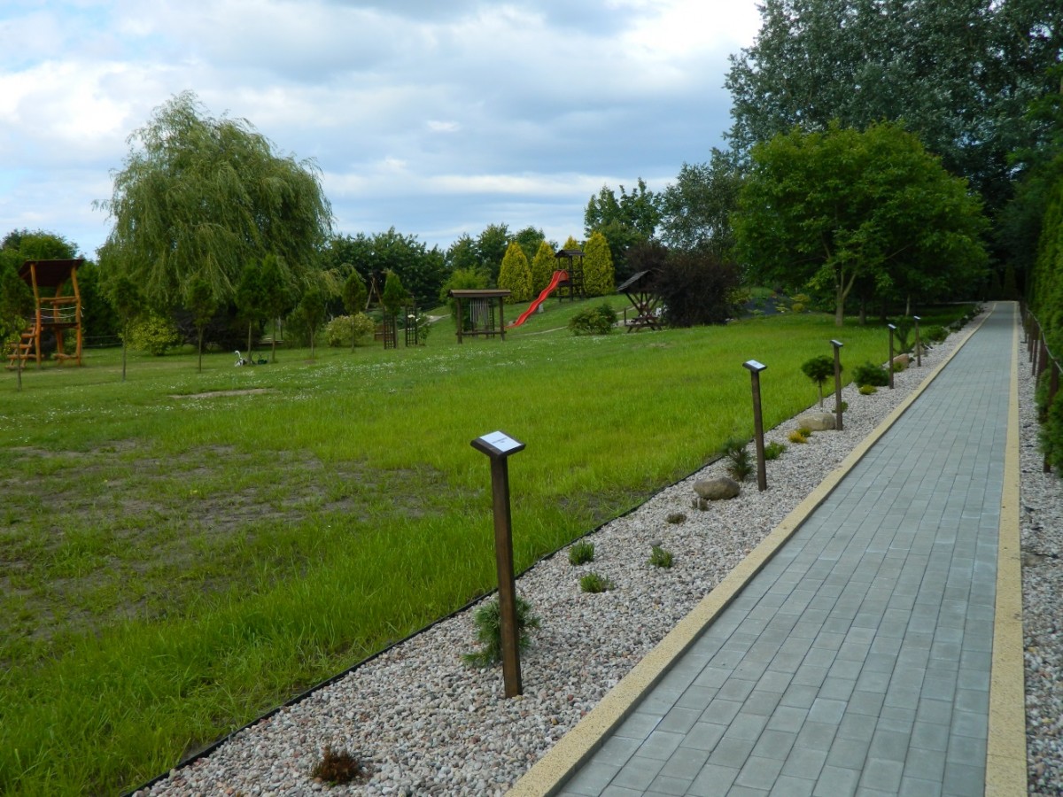 Ścieżka na terenie Ośrodka Rehabilitacyjno-Wypoczynkowego w Sobieszewie; wzdłuż ścieżki tablice informacyjne z nazwami posadzonych drzew