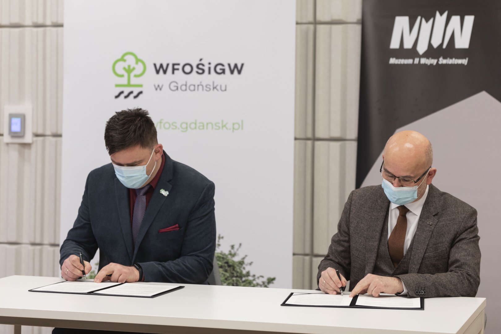 Podpisanie porozumienia pomiędzy WFOŚiGW w Gdańsku a Muzeum II Wojny Światowej. Na zdjęciu szefowie tych instytucji podpisują dokumenty.